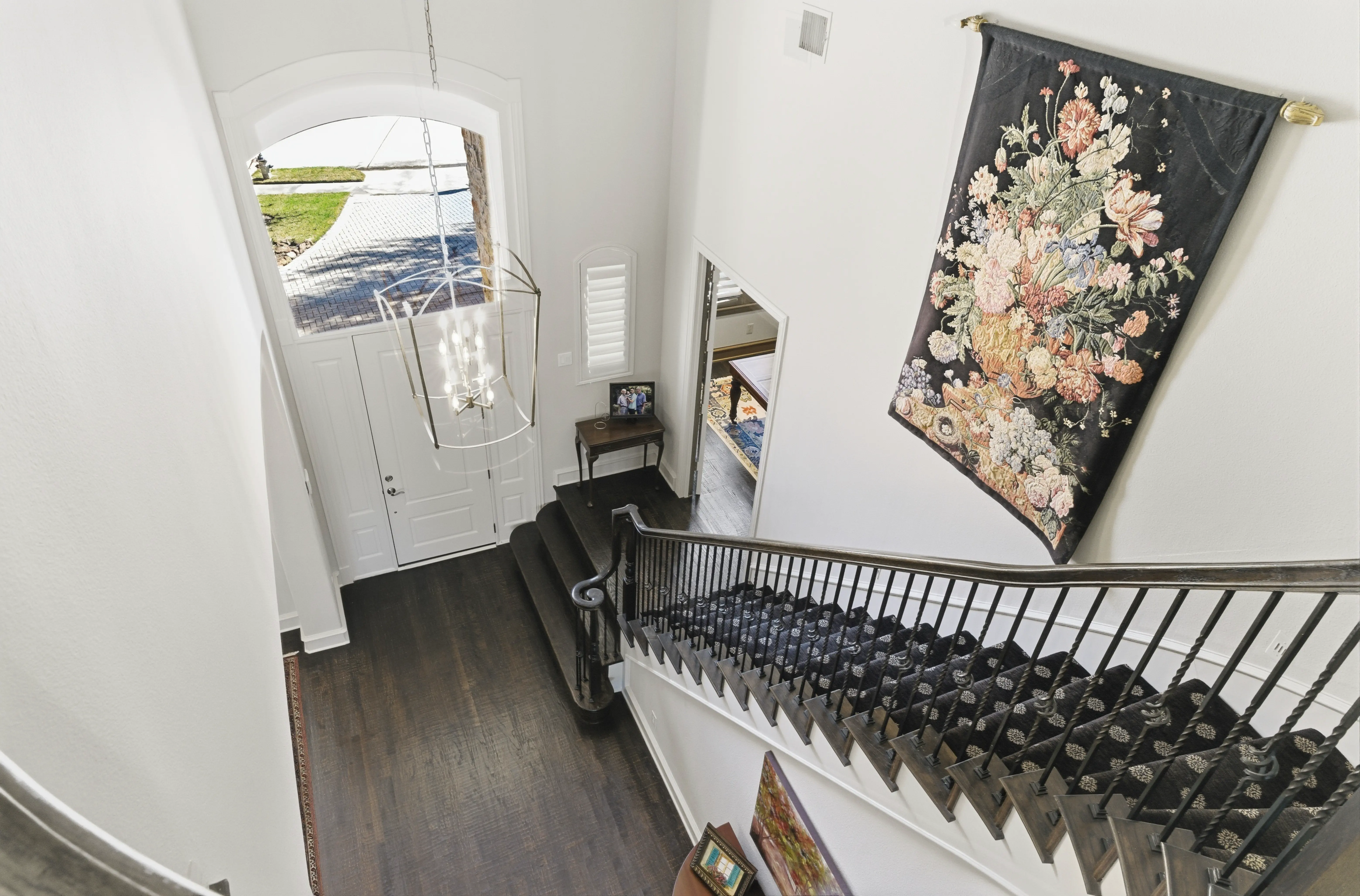 Dramatic two-story staircase with dark wood railings and white balustrade